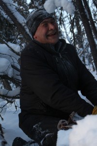Angus Charlo smiles as he strips birch bark from a tree for firestarter at Duck Lake in Yellowknife, NWT.