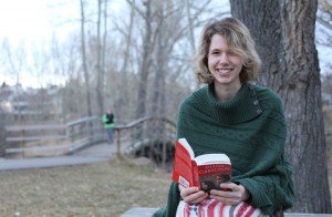 Erika Thompson looks up from her book to smile for the camera at Confederation Park in Calgary, Alberta.